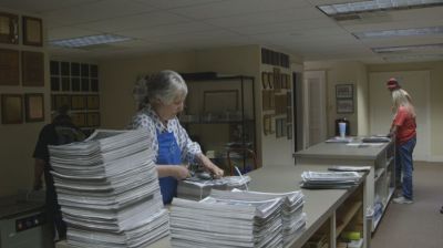 Canadian Record News Editor Cathy Ricketts prepares the newspapers for sale.