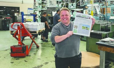 Matt Nelson holds a copy of the Mountain Times.