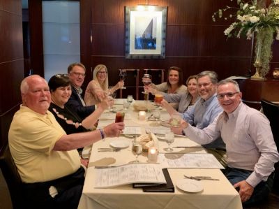 Newspaper Association Managers (NAM) toast longtime postal consultant Max Heath  as they meet in Madison, Wisconsin, for their annual meeting. Clockwise from front left: David Thompson, Kentucky Press Association; Teresa Thompson and Dave Bordewyk, South Dakota Newspaper Association; Lynne Lance, National Newspaper Association; Monica Gilmore, Mississippi Press Association; Felicia Mason, Alabama Press Association; Layne Bruce, Mississippi Press Association; Jim Fogler, Florida Press Association.