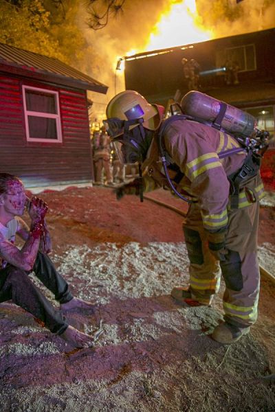A firefighter checks on the well-being of the male victim as the fire rages on. (Jenny Kirchner | Idyllwild (California) Town Crier) A firefighter checks on the well-being of the male victim as the fire rages on. (Jenny Kirchner | Idyllwild (California) Town Crier)