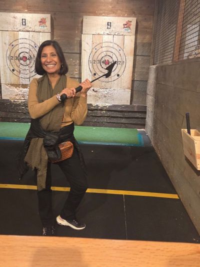 NNA Chair Martha Diaz Aszkenazy, publisher of The San Fernando Valley (California) Sun, displays a two-handed grip for axe throwing at The Fair on 4th at the Mall of America. She scored a bullseye!